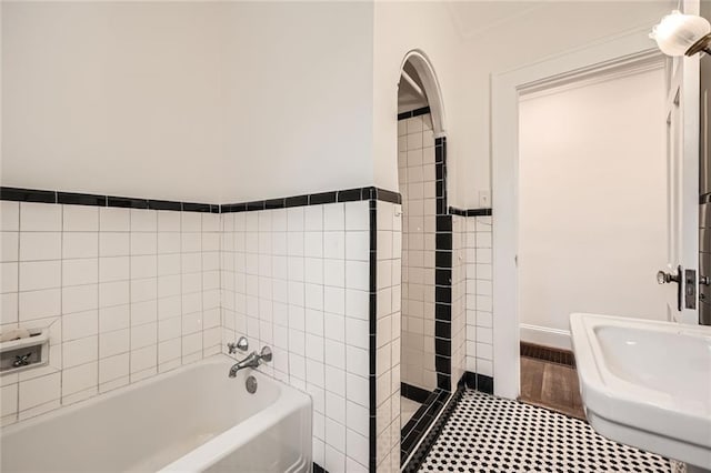 bathroom featuring tile walls and a garden tub