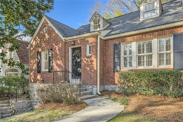 view of front of home with brick siding and a shingled roof