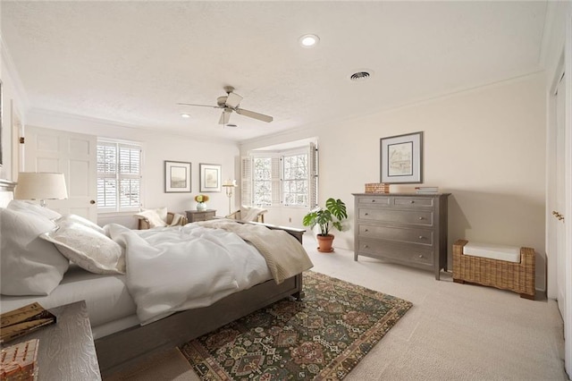 bedroom featuring visible vents, multiple windows, carpet floors, and ornamental molding