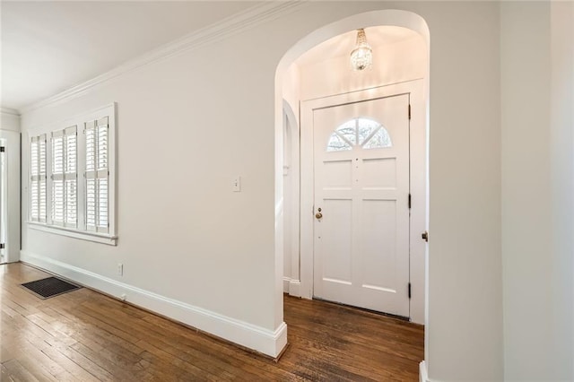 entrance foyer with hardwood / wood-style floors, visible vents, arched walkways, and ornamental molding