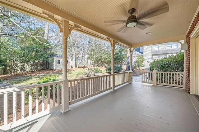 exterior space featuring a porch, an outdoor structure, and ceiling fan