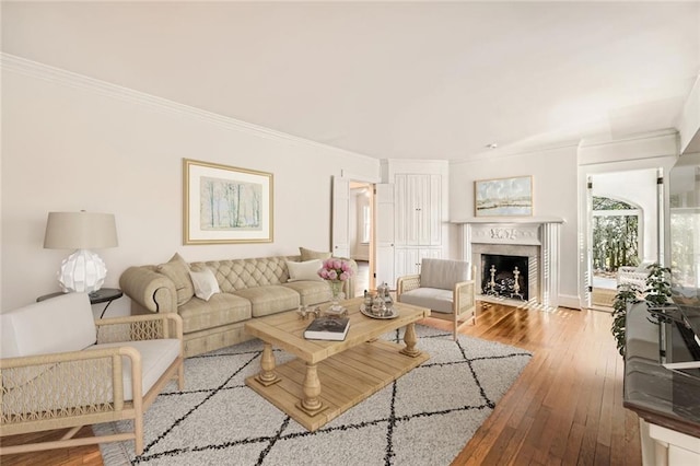 living room featuring hardwood / wood-style floors, crown molding, and a premium fireplace