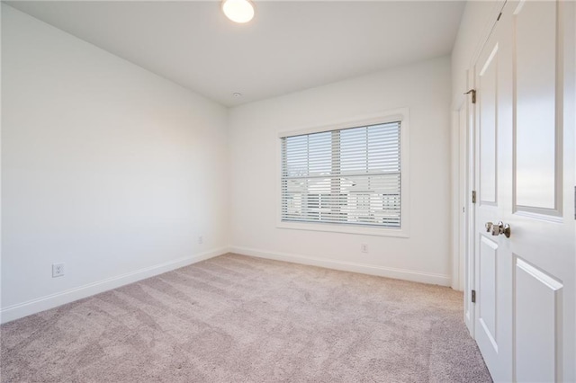 spare room featuring light colored carpet