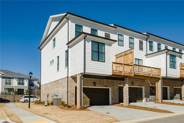 view of front of house with a balcony, a garage, and central air condition unit