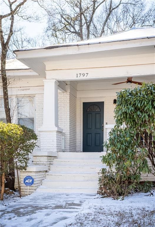 snow covered property entrance featuring covered porch