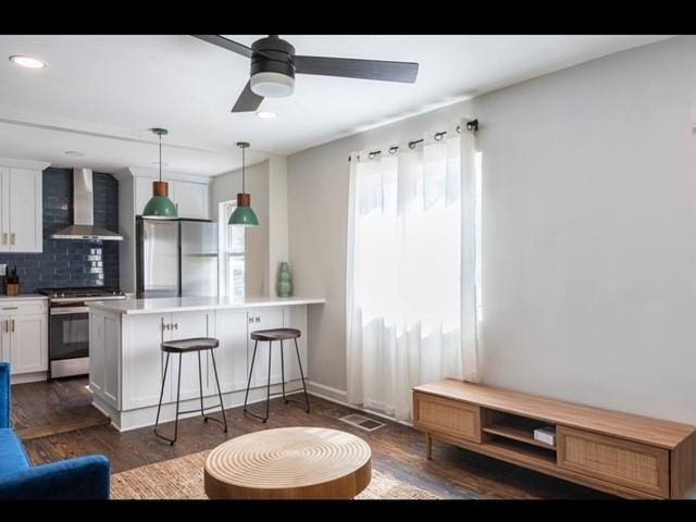205 Maple St, Atlanta, GA 30354 - kitchen with wall chimney range hood, appliances with stainless steel finishes, a breakfast bar, tasteful backsplash, and white cabinets