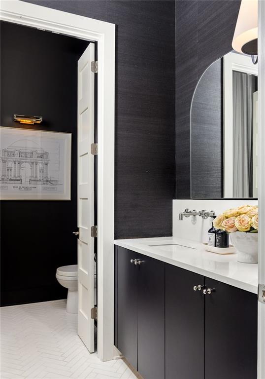 bathroom featuring toilet, vanity, and tile flooring