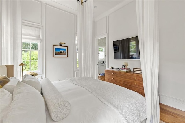 bedroom featuring hardwood / wood-style floors and a high ceiling