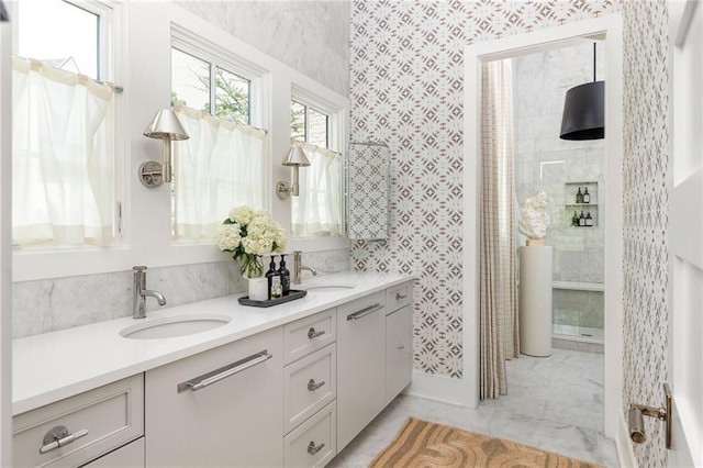 bathroom with tile floors, tiled shower, and dual vanity