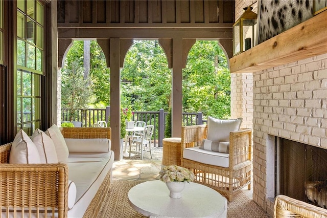 sunroom / solarium featuring an outdoor brick fireplace and a wealth of natural light