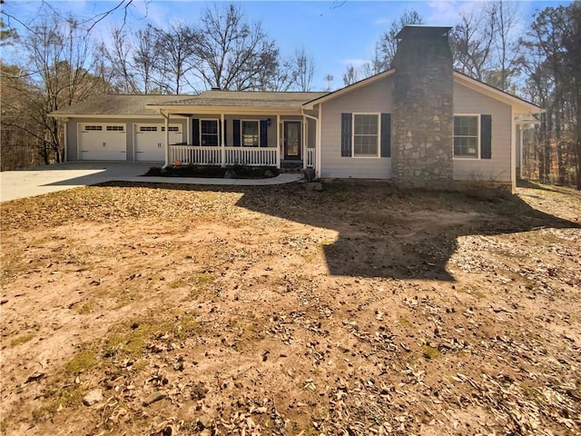 ranch-style home featuring an attached garage, covered porch, a chimney, and concrete driveway