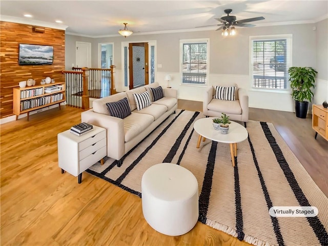 living room with light wood finished floors, ornamental molding, wood walls, and recessed lighting