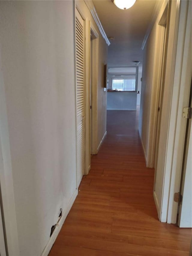 hall with hardwood / wood-style floors and crown molding