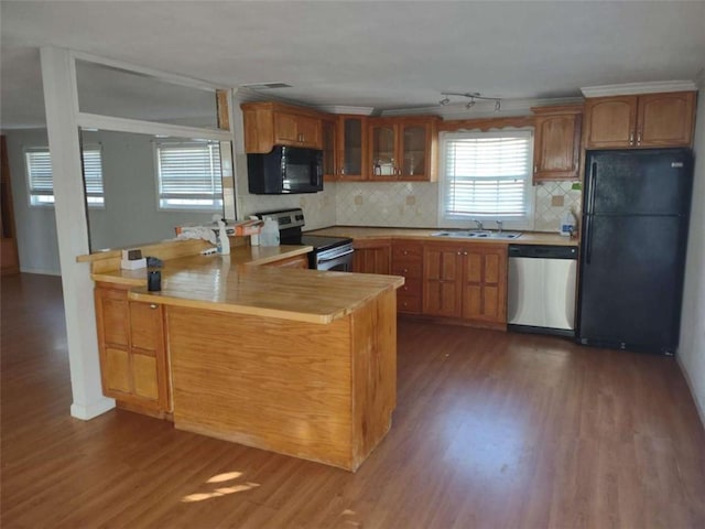 kitchen featuring backsplash, black appliances, sink, dark hardwood / wood-style floors, and kitchen peninsula