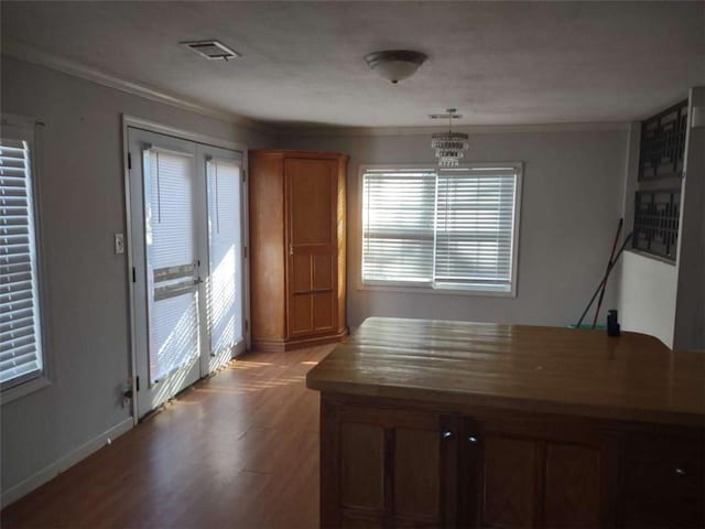 unfurnished dining area with crown molding, light hardwood / wood-style flooring, and a chandelier