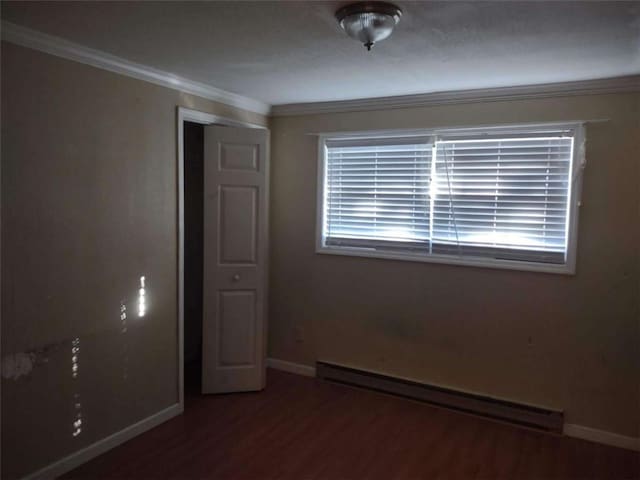 spare room with hardwood / wood-style floors, ornamental molding, and a baseboard heating unit