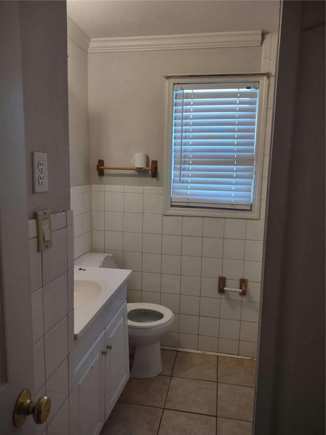 bathroom with vanity, tile patterned floors, crown molding, toilet, and tile walls