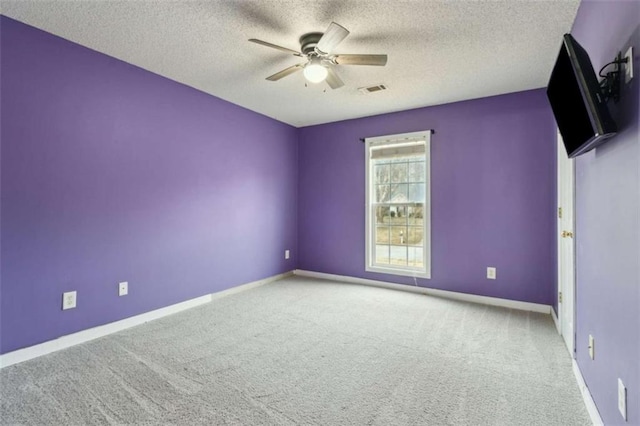 carpeted empty room with ceiling fan and a textured ceiling