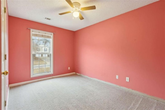 spare room with ceiling fan, a textured ceiling, and carpet