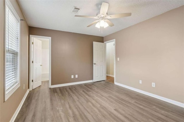 unfurnished bedroom with ceiling fan, light hardwood / wood-style floors, and a textured ceiling