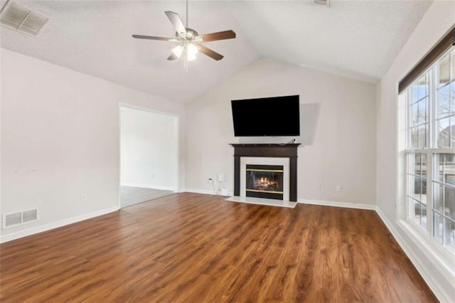 unfurnished living room featuring ceiling fan, dark wood-type flooring, and vaulted ceiling