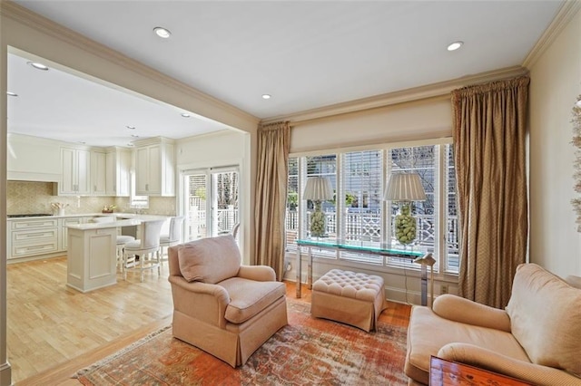 living area featuring ornamental molding and light wood-type flooring