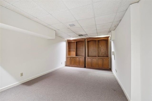 basement featuring light carpet and a drop ceiling