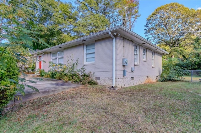 view of property exterior with a lawn and a patio