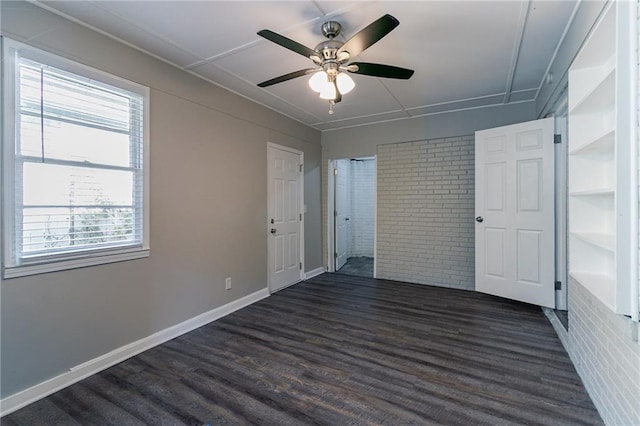 2308 Sheryl Dr, Decatur, GA 30032 - unfurnished bedroom with multiple windows, brick wall, dark wood-style floors, baseboards, and a ceiling fan