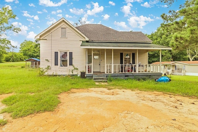 back of property with a porch and a shingled roof