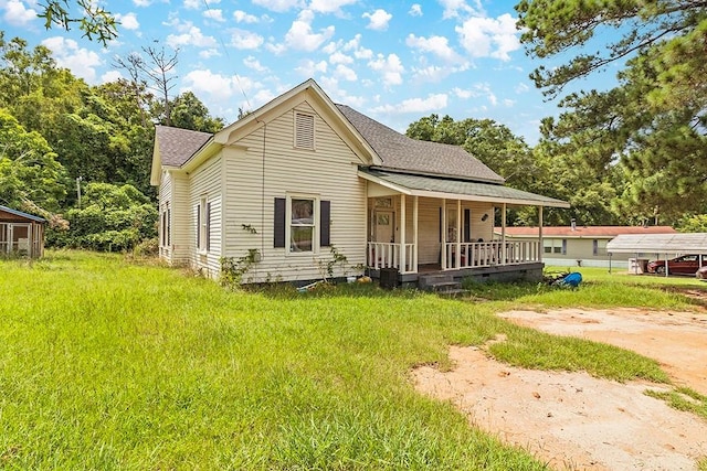 view of front facade featuring a shingled roof, covered porch, and a front lawn