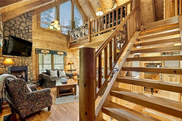 100 Black Oaks Rd, Cherry Log, GA 30522 - staircase featuring a wood ceiling with exposed beams, hardwood / wood-style flooring, ceiling fan, a fireplace, and wood walls