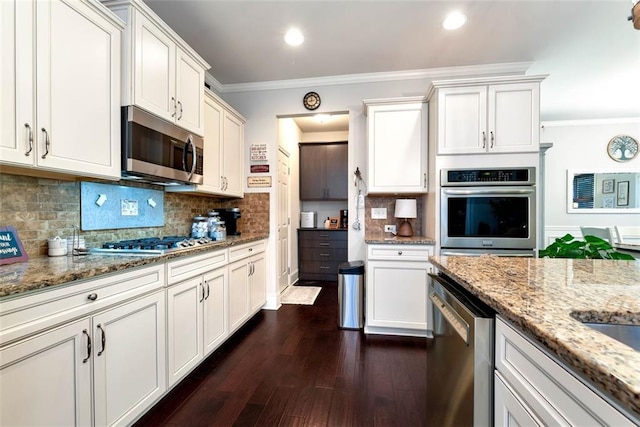 6628 Rivergreen Rd, Flowery Branch, GA 30542 - kitchen with appliances with stainless steel finishes, ornamental molding, dark wood-style floors, light stone counters, and tasteful backsplash