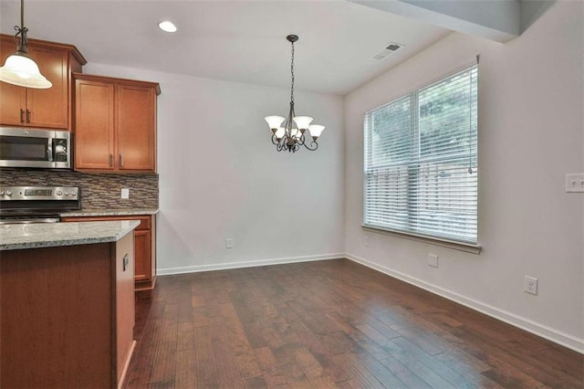 kitchen with backsplash, dark wood-type flooring, baseboards, light stone counters, and appliances with stainless steel finishes