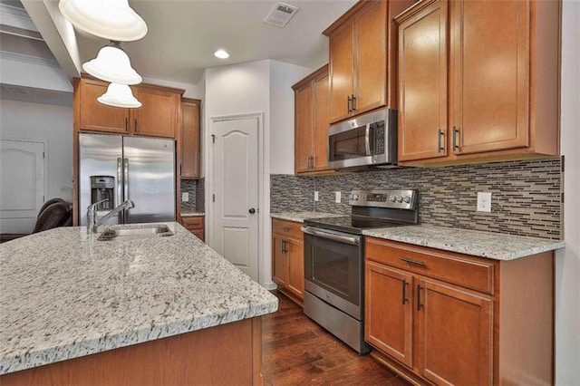 kitchen featuring dark hardwood / wood-style floors, backsplash, hanging light fixtures, stainless steel appliances, and sink