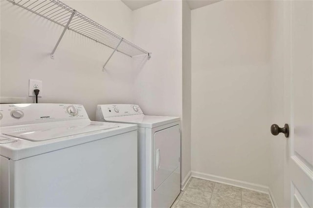 laundry room featuring washer and clothes dryer and light tile patterned flooring