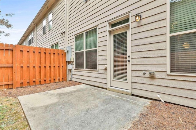 entrance to property featuring a patio area and fence