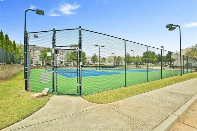 view of tennis court featuring fence and a gate