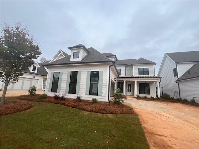 view of front facade with a porch, a garage, and a front lawn