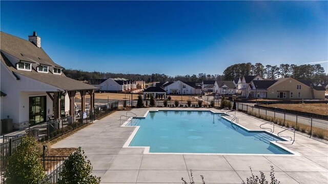 rear view of house with a patio area and a community pool