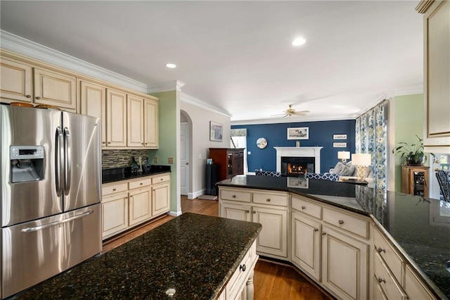 kitchen with stainless steel fridge, open floor plan, and cream cabinetry