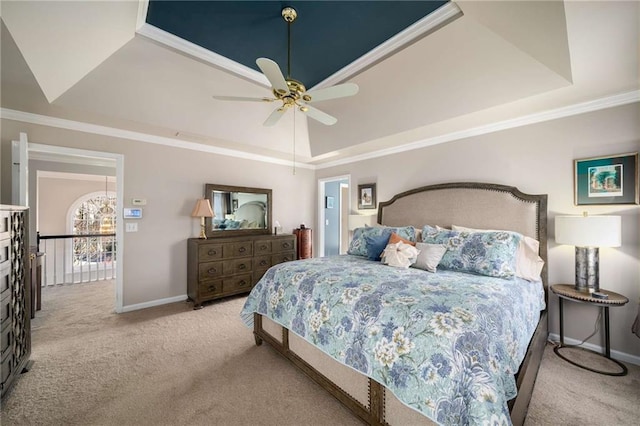 bedroom featuring a raised ceiling, light colored carpet, and baseboards