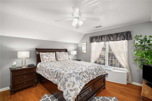 bedroom featuring lofted ceiling, baseboards, visible vents, and light wood-style floors