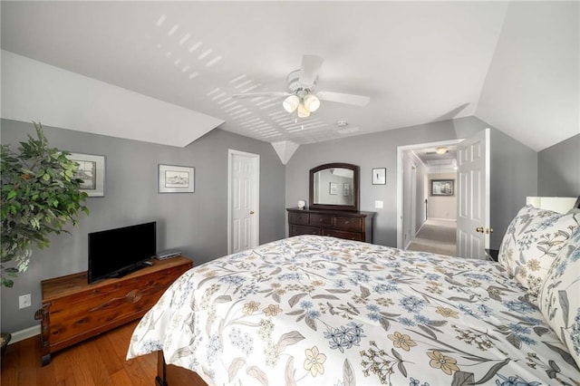 bedroom with lofted ceiling, baseboards, a ceiling fan, and wood finished floors