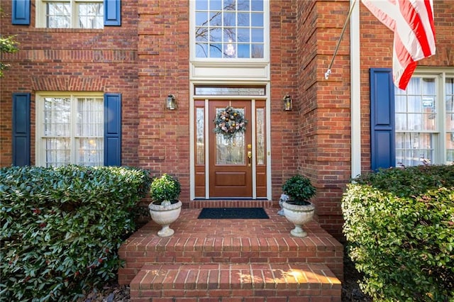 view of exterior entry featuring brick siding