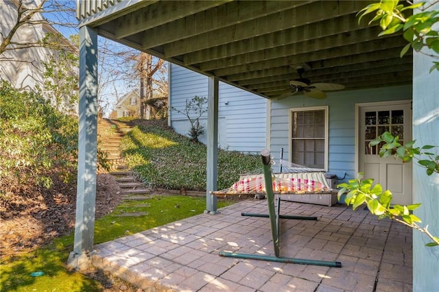 view of patio with a ceiling fan and stairs