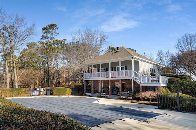 back of property featuring brick siding, a patio area, and a covered pool