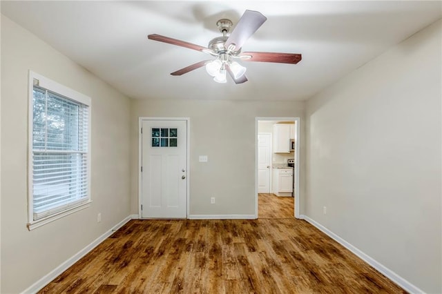 entrance foyer with baseboards, a ceiling fan, and wood finished floors