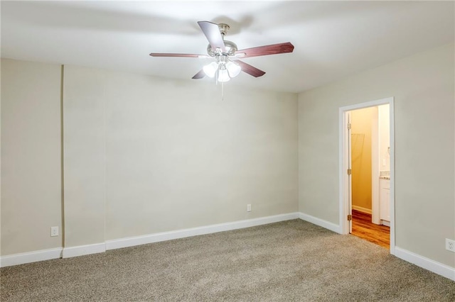 carpeted spare room with baseboards and a ceiling fan