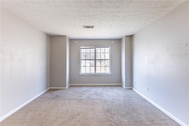 unfurnished bedroom featuring light colored carpet, visible vents, ceiling fan, ensuite bath, and baseboards